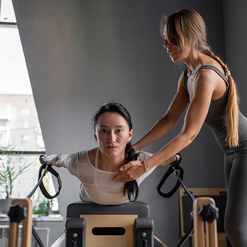 Personal trainer assisting back extension exercise in Congleton gym