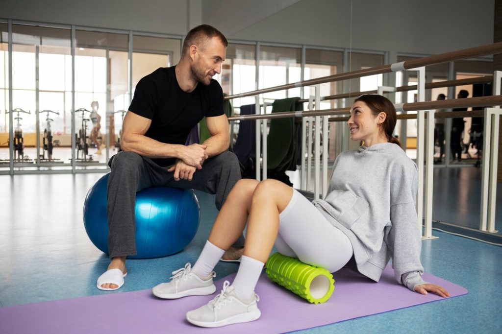 Personal trainer guiding a woman during stretching and recovery session at a Congleton gym UK