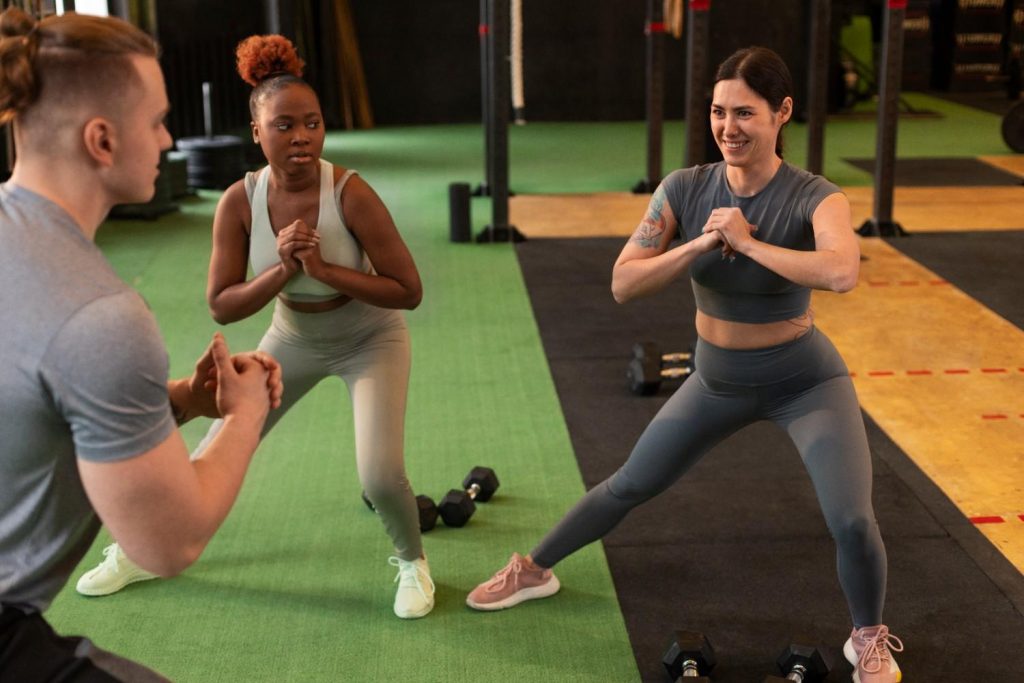 Personal training session in a UK gym with members doing lunges and strength exercises