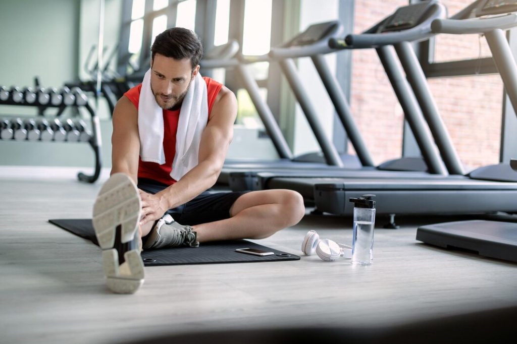 Man stretching legs after workout at Congleton gym in the UK