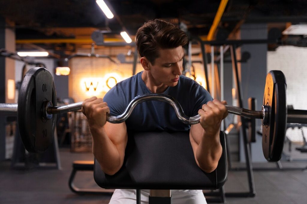 Man performing barbell bicep curls for strength training at Congleton gym UK