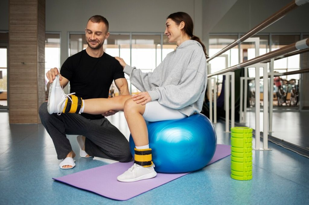 Trainer guiding resistance band leg exercise in Congleton gym