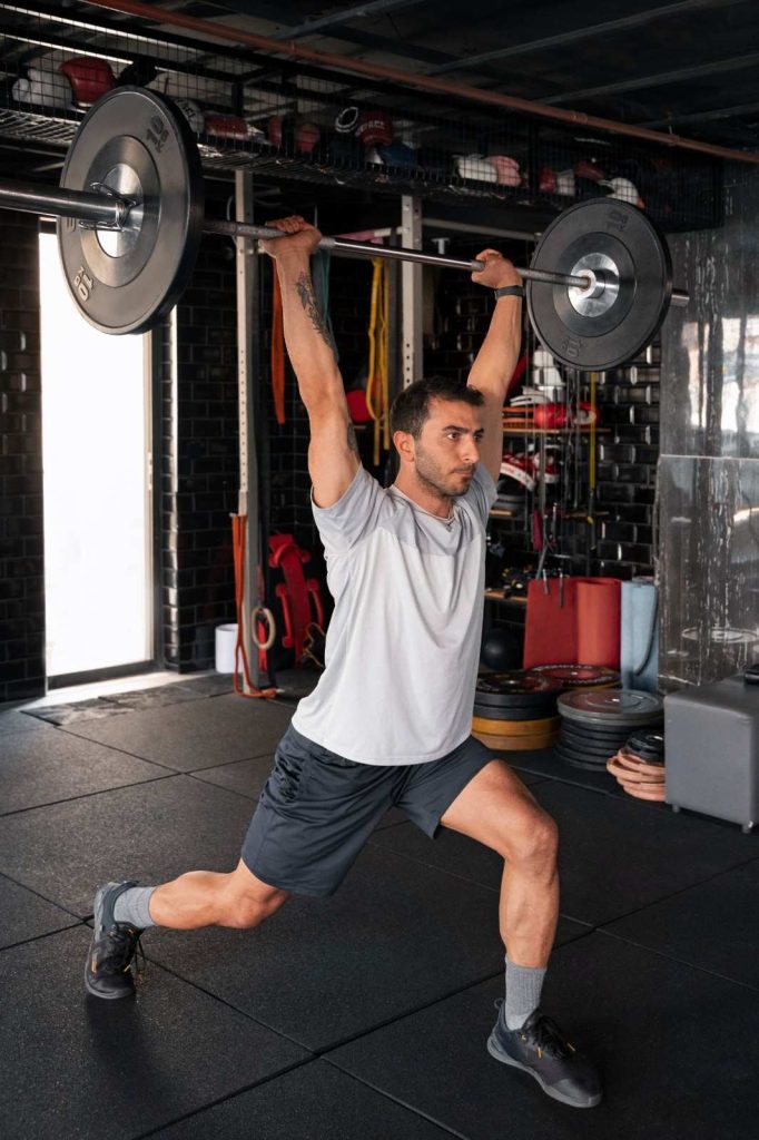 Man performing barbell overhead lunge in Congleton gym for strength training