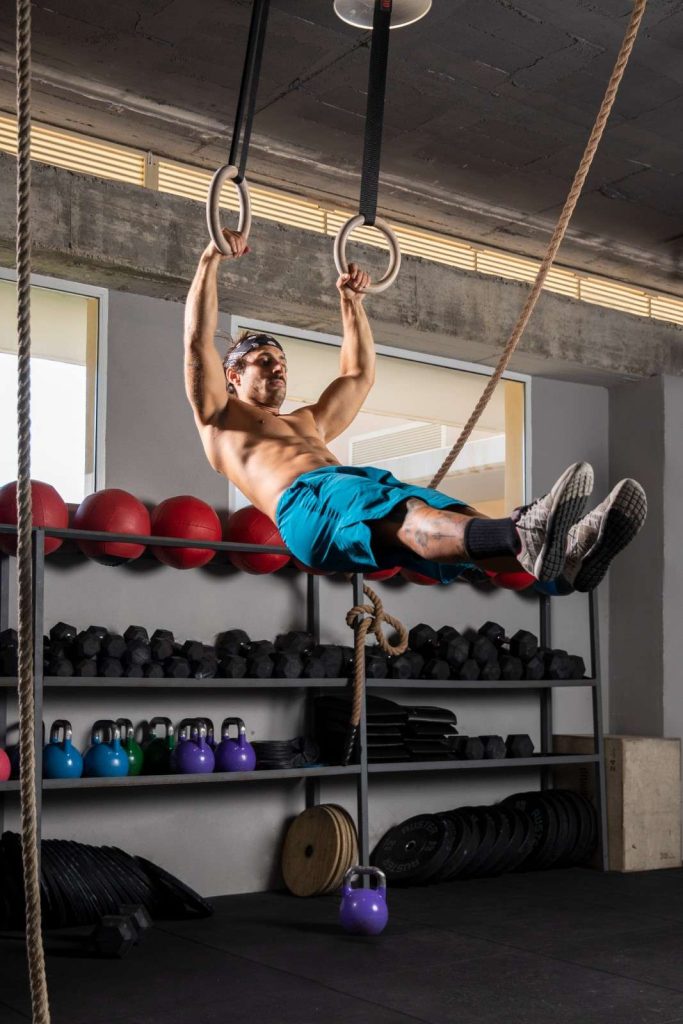 Man performing gymnastic rings exercise in Congleton gym for core strength