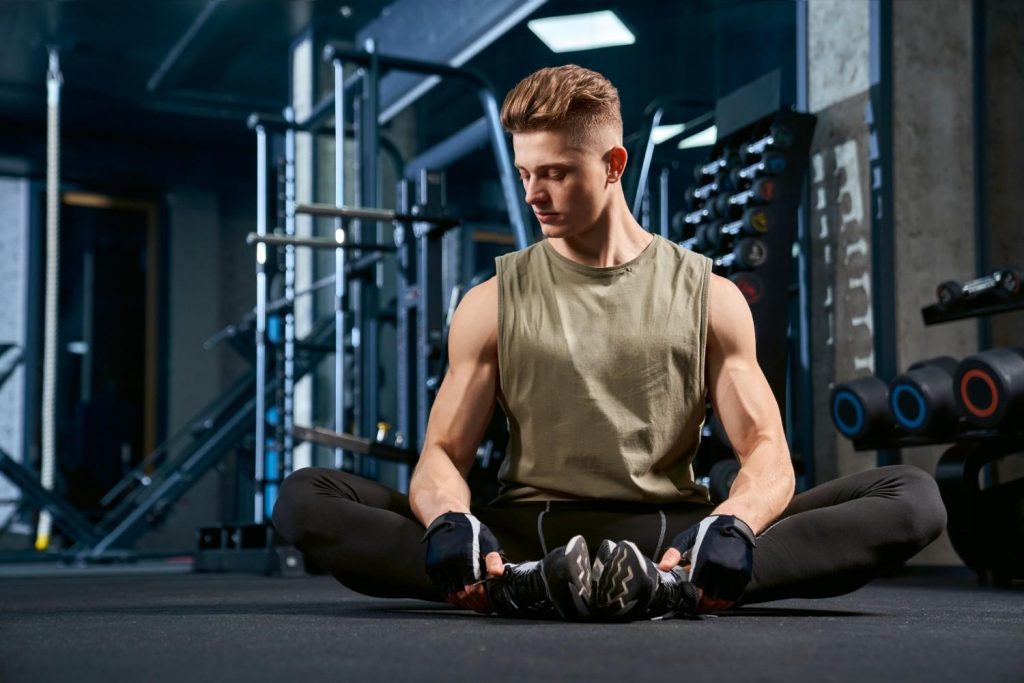 Man stretching after workout in Congleton gym on fitness floor