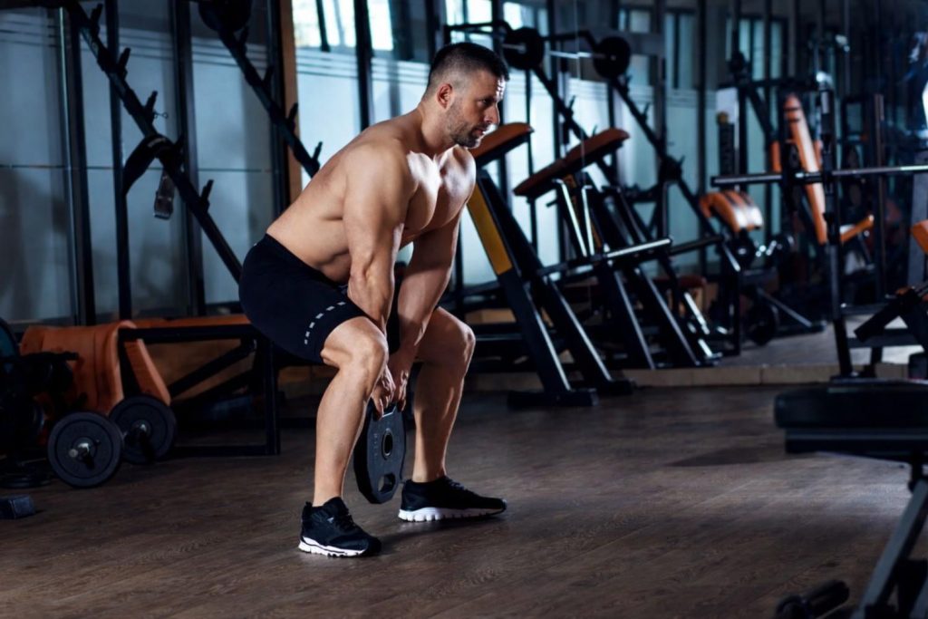 Man performing kettlebell deadlift in Congleton gym for strength training